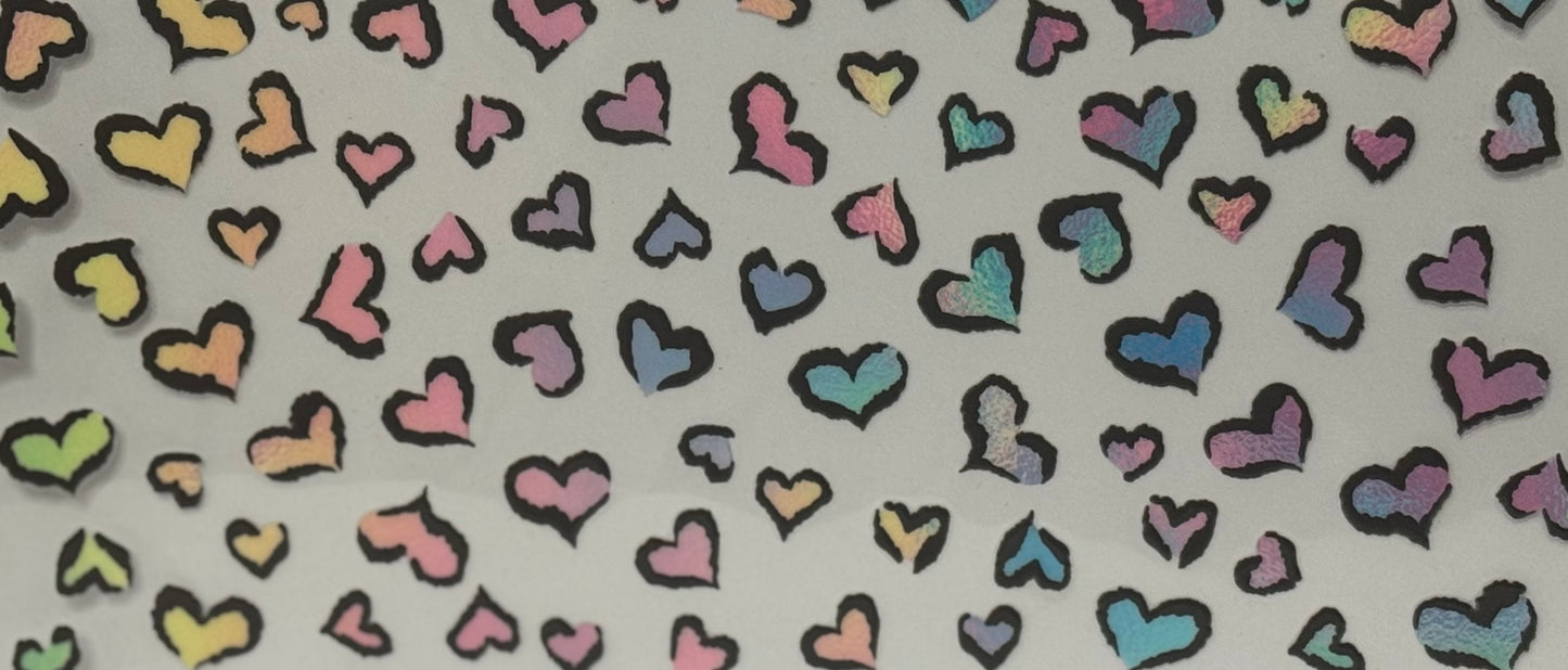 A pattern of rainbow-colored hearts with bold black outlines scattered across a light background.
