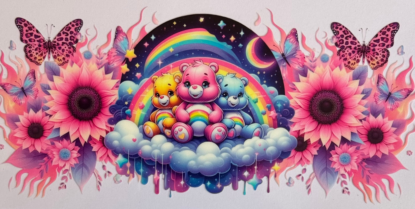Care Bear-themed DTF wrap with three bears on a cloud, rainbow background, pink sunflowers, and butterflies, sized 24x11cm for 16oz tumblers.