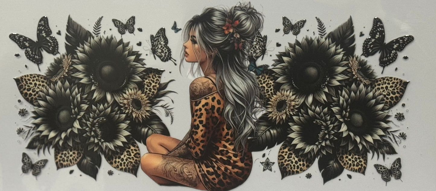 A girl in a leopard-print outfit sitting among large black sunflowers with butterflies around her.