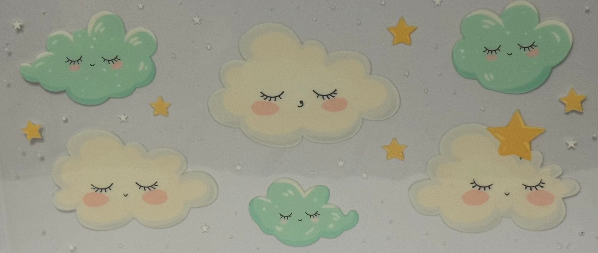 Cartoon pastel clouds with closed eyes and rosy cheeks surrounded by golden stars on a grey background.