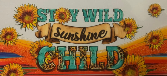  A colorful wrap featuring sunflowers with bold text reading “Stay Wild Sunshine Child” in turquoise and leopard print.
