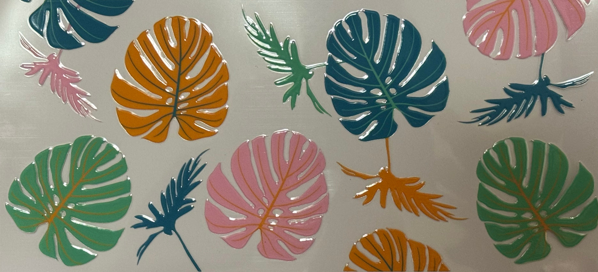 Bright tropical monstera and palm leaves in pink, orange, teal, green scattered across a clear background.