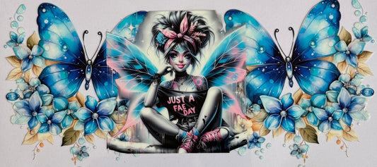 Fairy girl with neon wings sits between two large blue butterflies and blue florals; shirt reads “Just a Fae Day